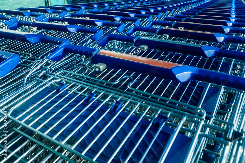 Many shopping carts parked in front of a supermarket. Many shopping carts parked in front of a supermarket.