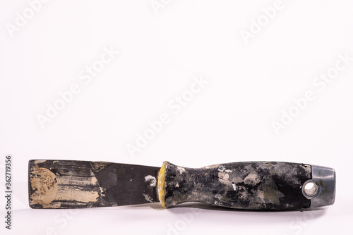 Well-used putty knife with paint on handle and blade isolated on a white background