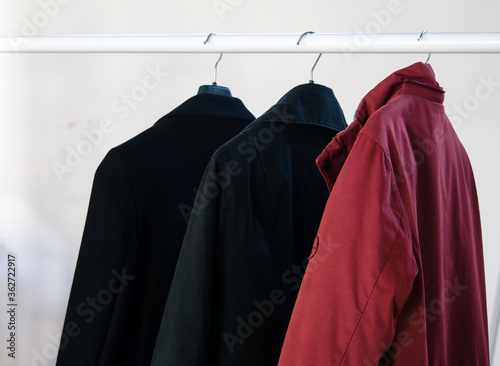 Three coats hanging on a coat rack. photo