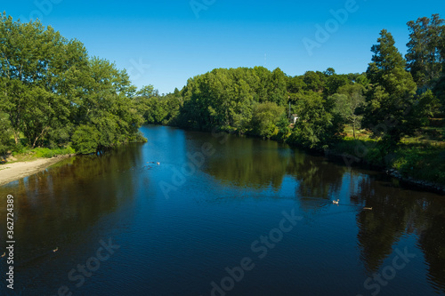 Beautiful summer landscape over River Ave in rural Portugal  on a sunny summer day with blue sky and lush green trees.