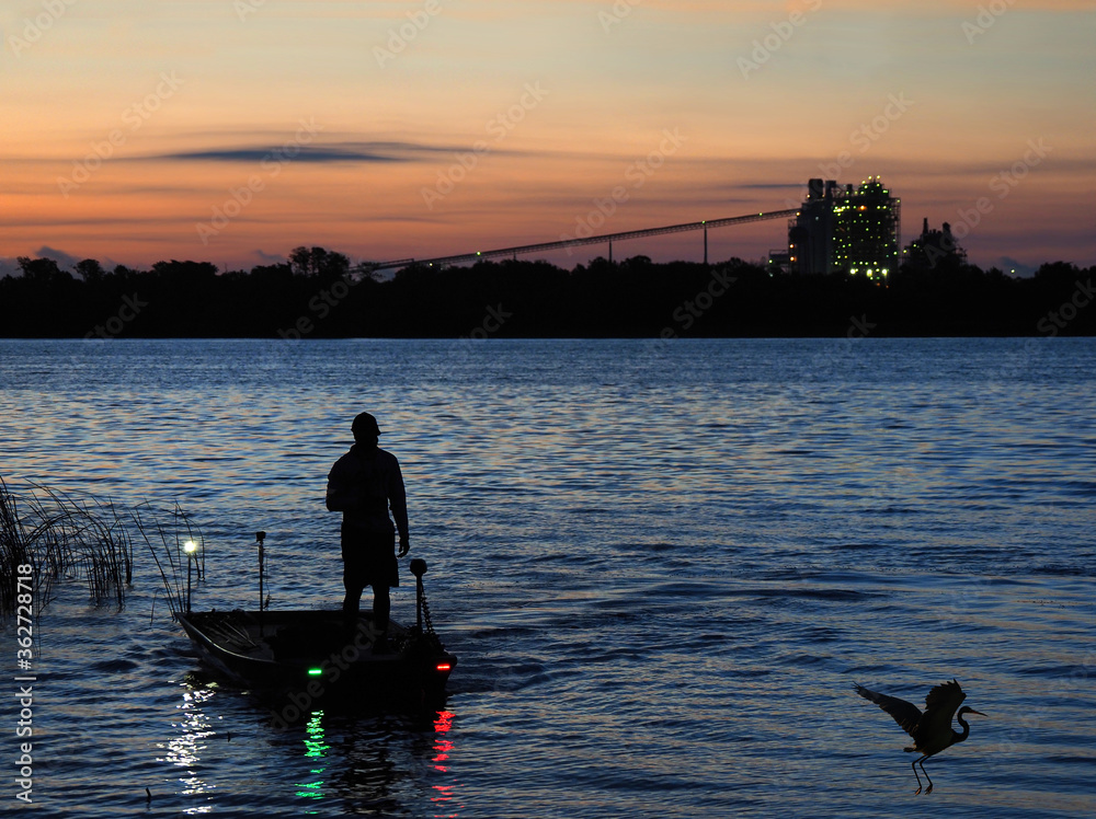 A Fisherman in a Small Well Equipped John Boat Begin His Day Fishing with a Beautiful Sunrise A Fisherman in a Small Well Equipped John Boat Begin His Day Fishing with a Beautiful Sunrise