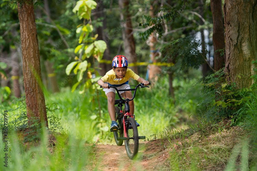 Naklejka premium Asian boy is training for a happy mountain biking.