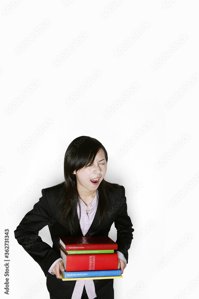 Businesswoman carrying a heavy stack of books Businesswoman carrying a heavy stack of books