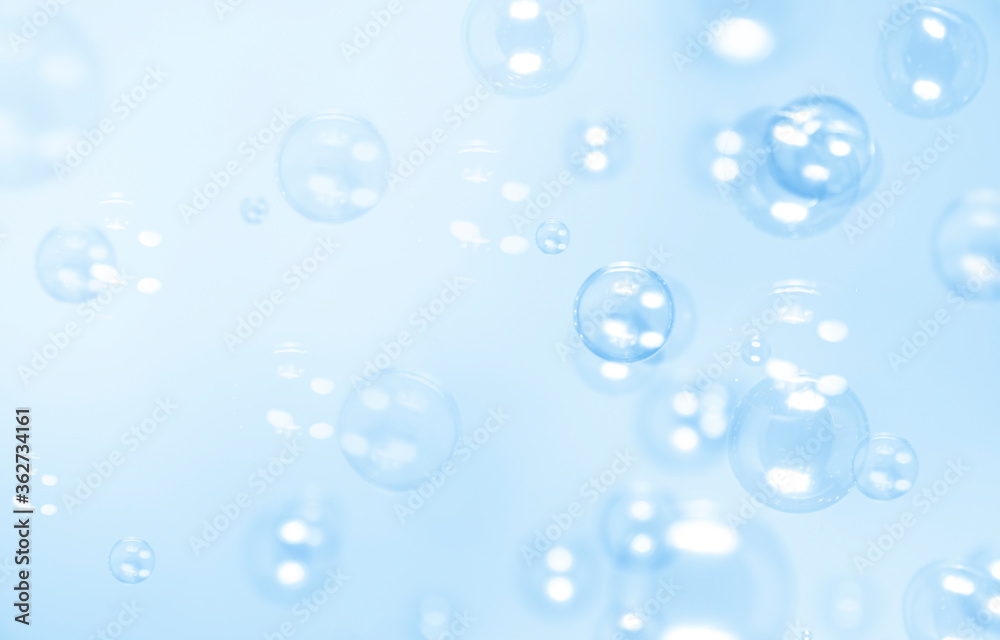 Clear blue soap bubbles float in the air. Abstract blur background.
