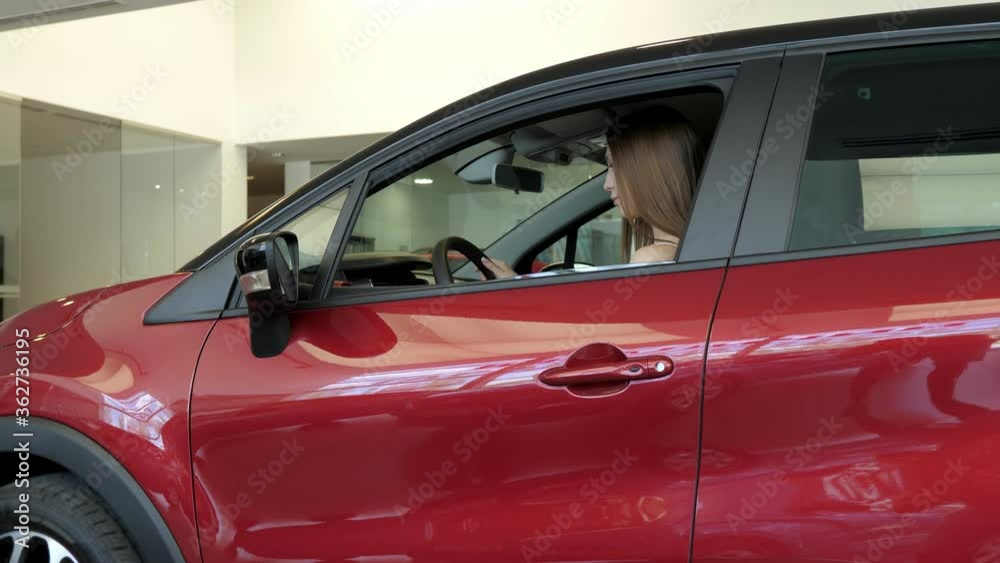 Lady in a car salon. Elegant woman choosing the car Lady in a car salon. Elegant woman choosing the car