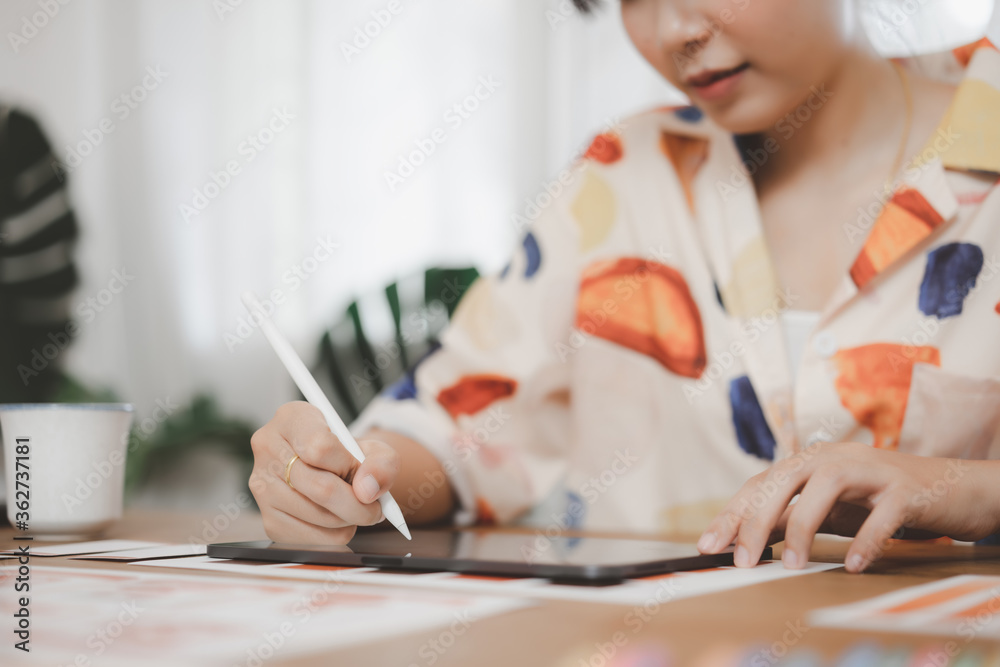 Creative graphic designer using digital pen drawing on tablet while working at home office. Creative graphic designer using digital pen drawing on tablet while working at home office.