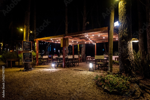 Night scene of an elegant outdoor bar illuminated by small hanging bulbs