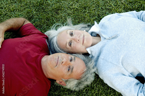 Tablou pe pânză Old couple lying on the grass