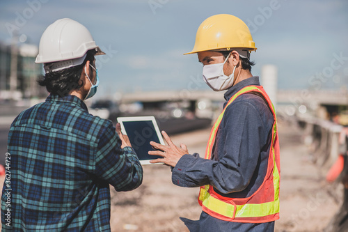 Engineering holding tablet work on road construction