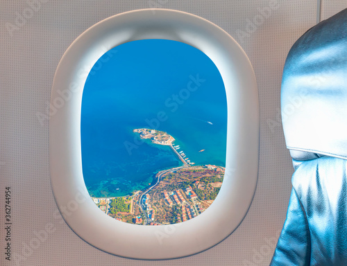 Kusadasi island with ships as seen through window of an commerical passenger airplane