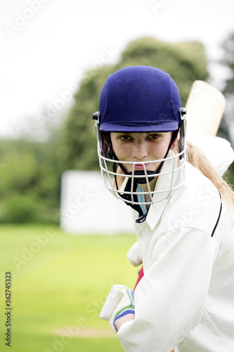 Female cricket player holding a cricket bat