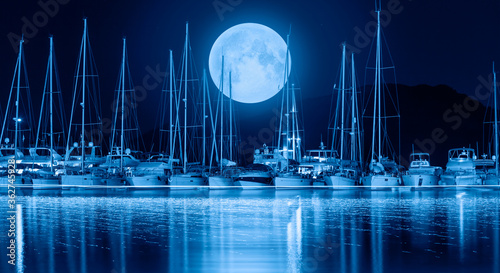 Sailing boats in marina at night amazing moon rising in the background -  Selimiye Turkey 