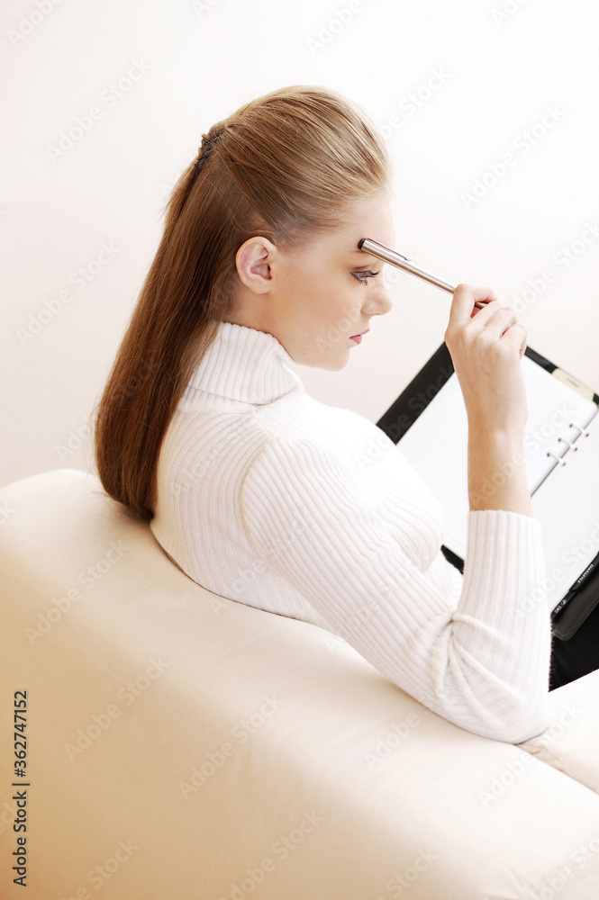 Businesswoman writing in an organizer