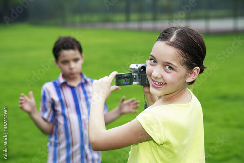 Girl recording images of boy making a face © ImageHit