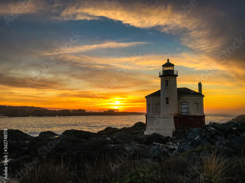 Dramatic evening sky with clouds over Oregon Lighthouse, warm sunset