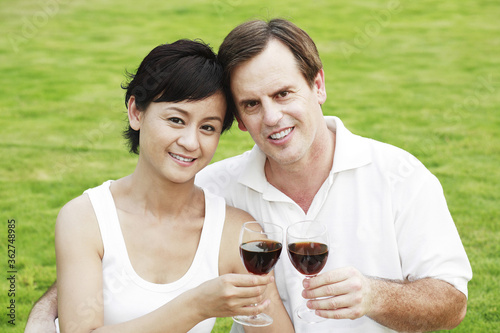Husband and wife holding glasses of wine © ImageHit