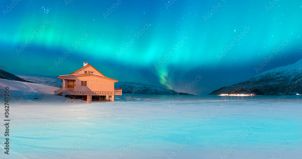 Aurora Borealis in Tromso, Norway in front of the Norwegian fjord - Winter season.