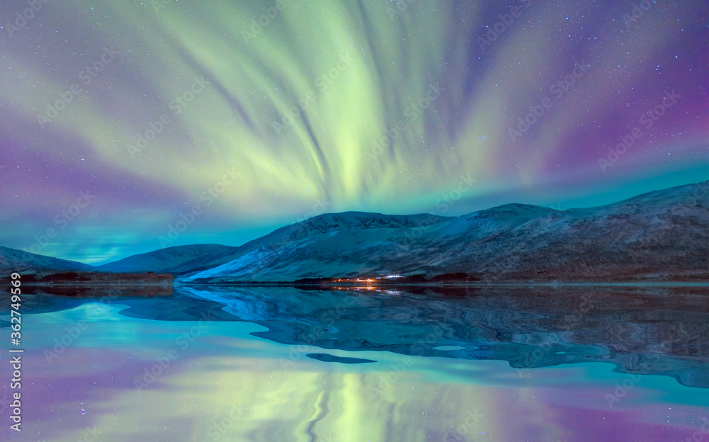 Aurora Borealis in Tromso, Norway in front of the Norwegian fjord - Winter season.