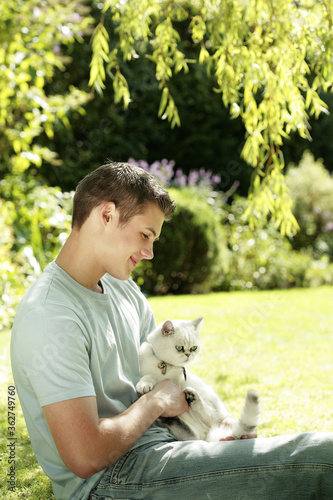 Young man holding a cat in his arms