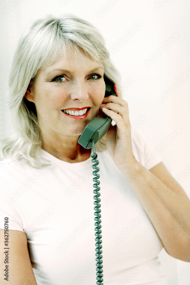 Woman smiling while talking on the phone Woman smiling while talking on the phone