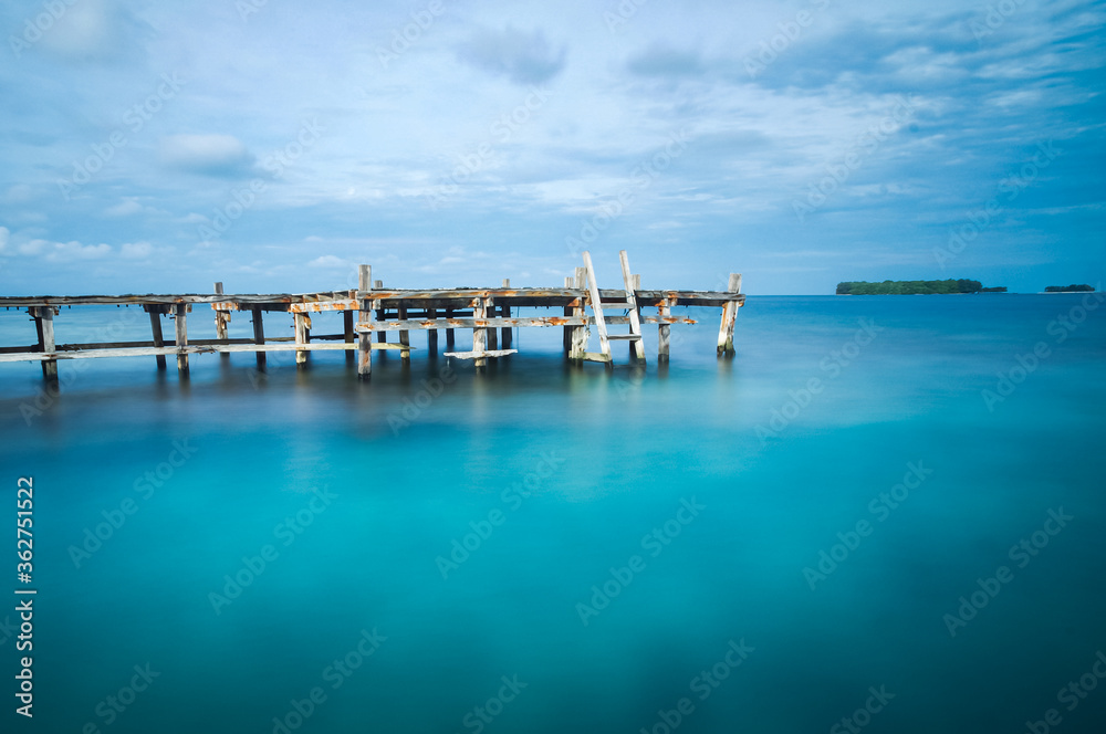 Wooden bridge on a blue sea. Long exposure photo