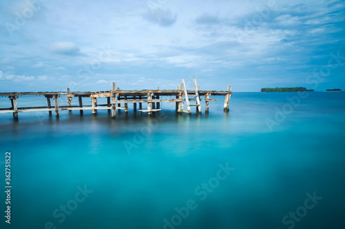 Wooden bridge on a blue sea. Long exposure photo