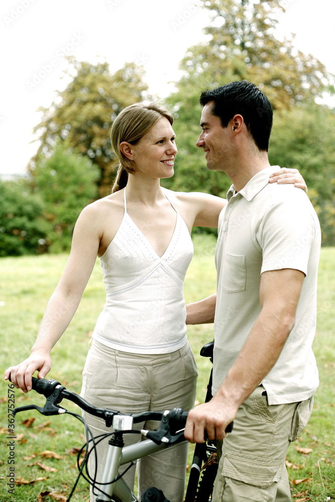 Obraz premium Couple and a bicycle in the park