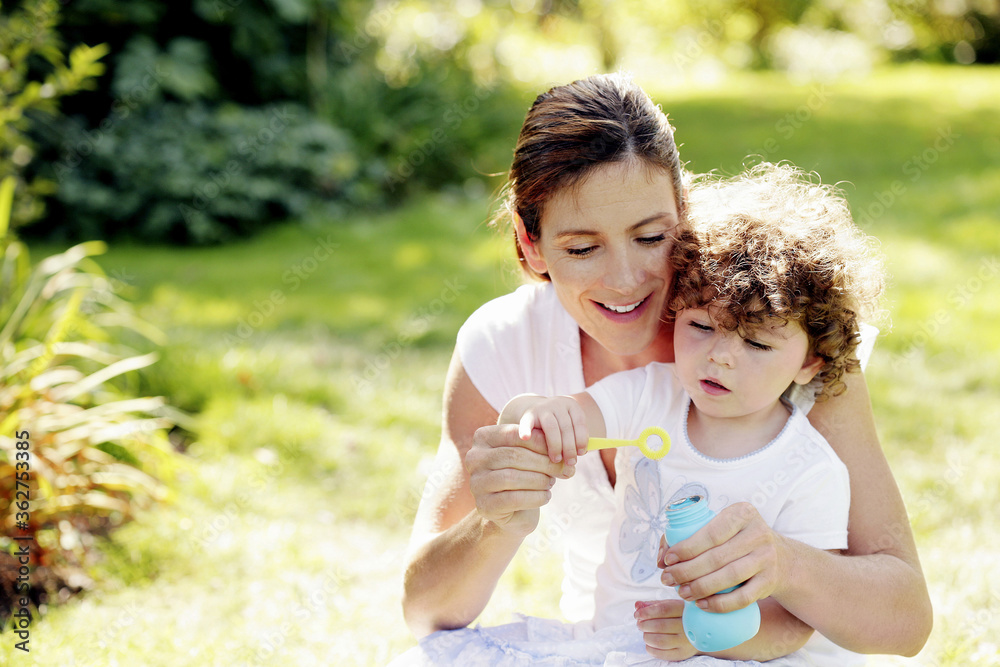 Mother and daughter playing with soap bubbles Mother and daughter playing with soap bubbles