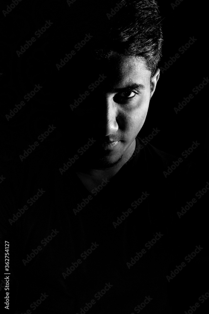 Confident looking of a young man dramatic low key black and white portrait