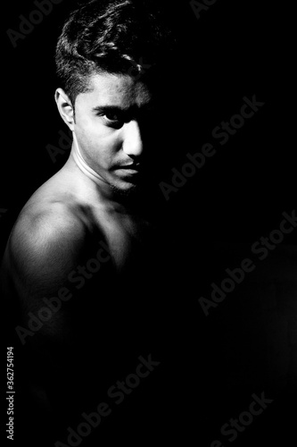 Confident looking of a young man dramatic low key black and white portrait