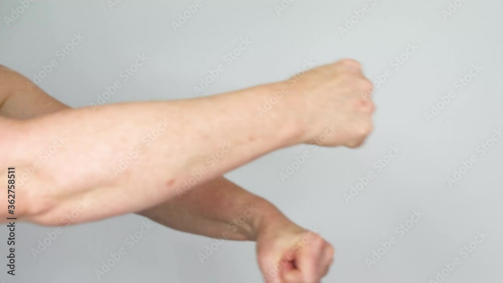 A senior rotates her arms in a rolling action showing the struggle of motion with arthritis. A senior rotates her arms in a rolling action showing the struggle of motion with arthritis.