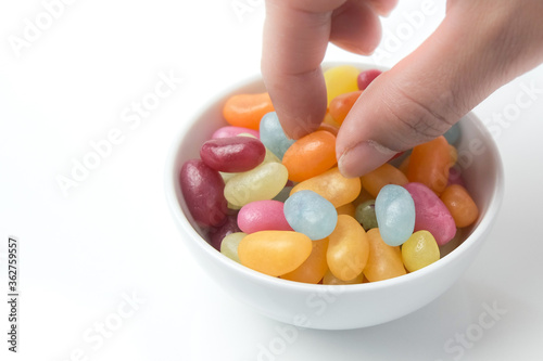 Foto Picking up a jelly bean from bowl of brightly colored candy