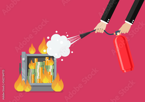 Businessman with fire extinguisher is fighting with the burning metal safe