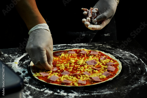 Tomato sauce and butter cheese on top pizza dough garnish with quality ingredients.. An important trick for making tasty and appetizing pizza is to prepare quality pizza dough and sauces.