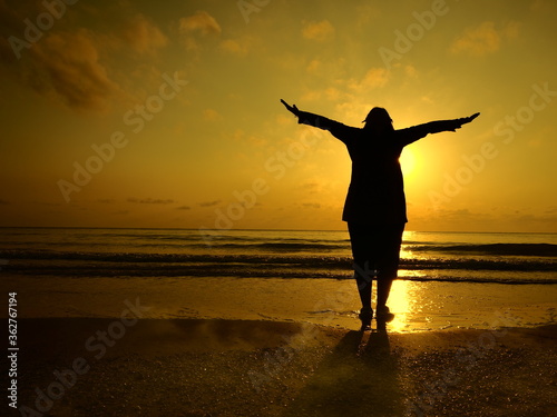silhouette of a woman on the beach at sunset