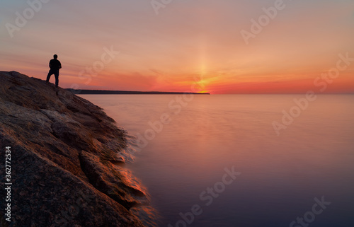sunset on the shore of Lake Ladoga and the silhouette of a man