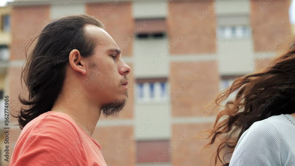 close up on young couple staring at each other angry on the street close up on young couple staring at each other angry on the street