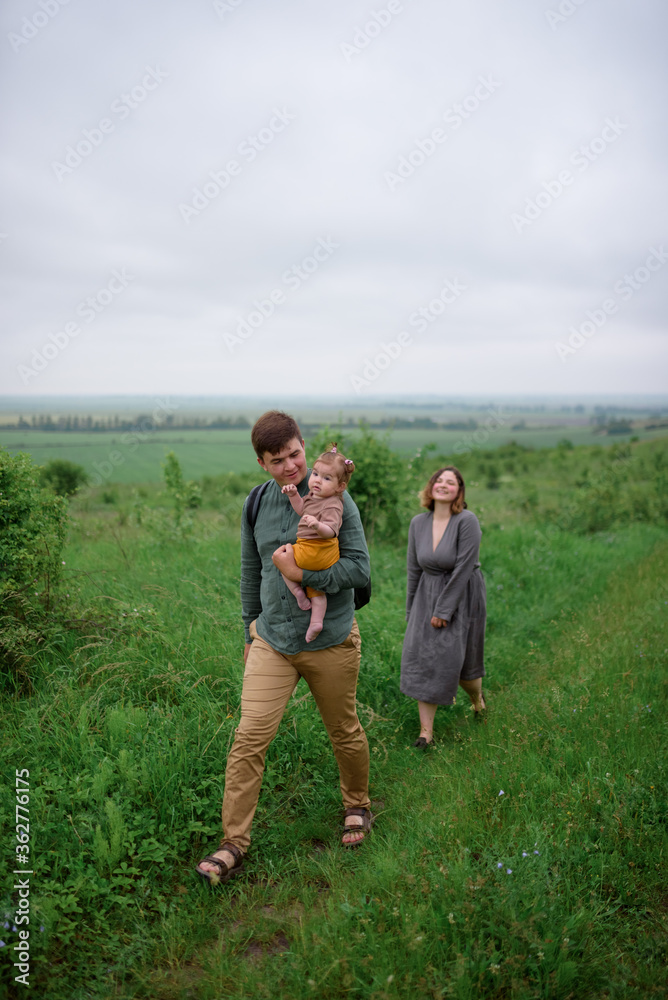 Mom, dad and daughter. Father holds his daughter in his arms.