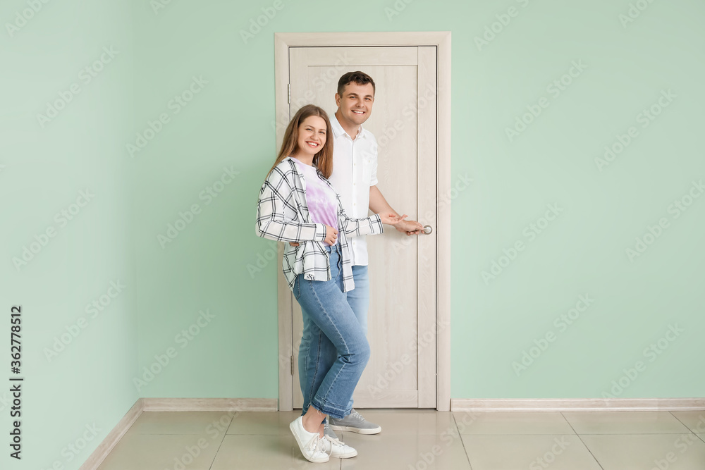 Happy couple inviting guest at their new home Happy couple inviting guest at their new home
