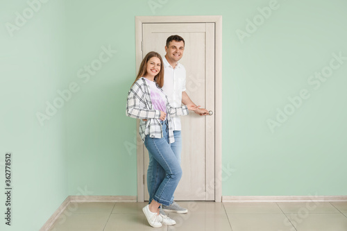 Happy couple inviting guest...