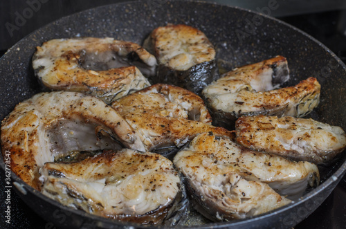 Fish steaks fried in a pan on an induction stove 