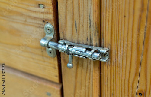 Vintage metal latch for a wooden door.