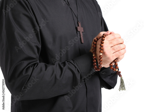 Young priest praying to God on white background, closeup