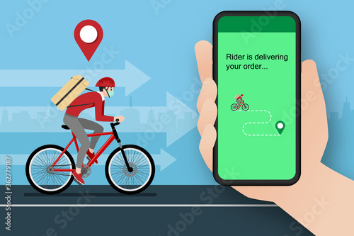 A delivery man who get an order from smart phone, delivering a parcel to customer by bicycle and the city in the background. Stay safe at home delivery during coronavirus covid-19 crisis concept.