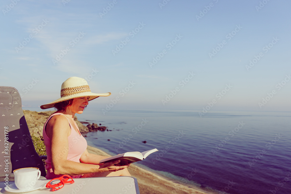 Fototapeta premium Woman on sea read book, relaxing