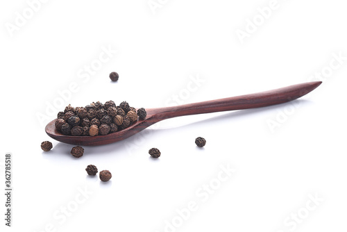 Photos Close up black peper in wooden spoon pile on white background.