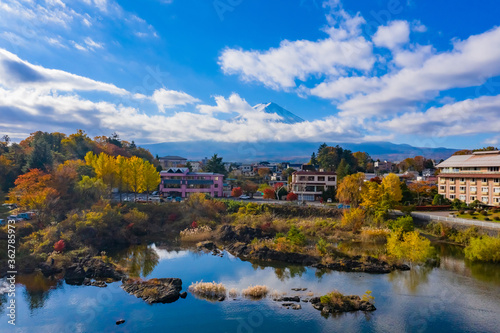 Japan. Hotels by the shores of Lake Kawaguchiko. Nature of Fujikawaguchiko. Mount Fuji beyond the clouds. Autumn trees on the shores of Lake Kawaguchiko. Kawaguchiko Lake has a red Japanese maple.