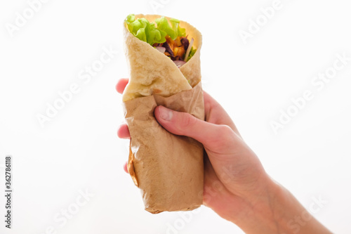 Mexican burrito in hand with chicken, pepper and beans photo