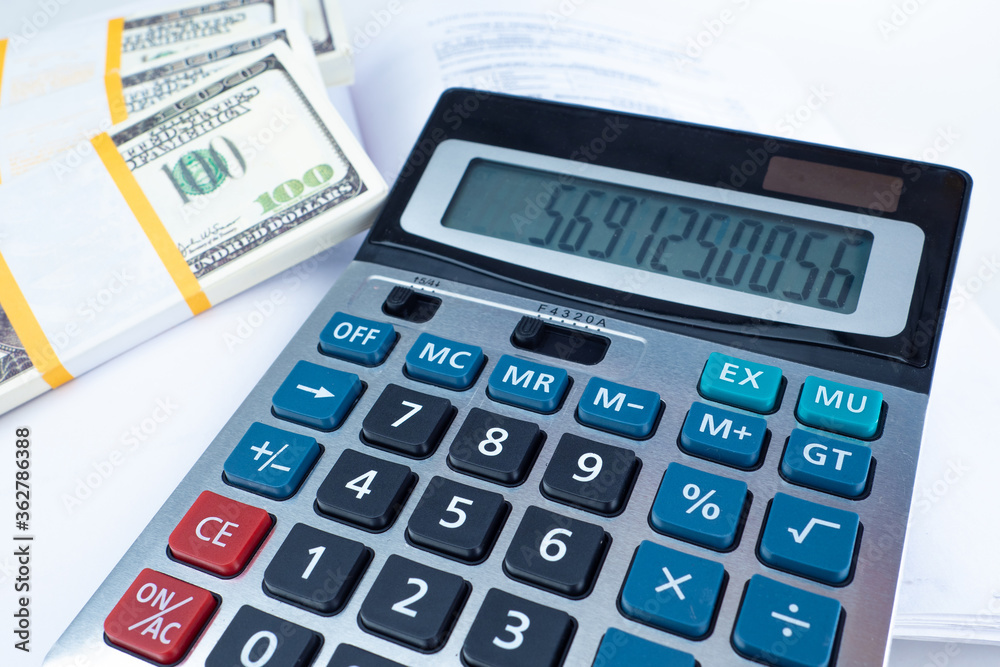 Bundles of money are next to the calculator. Counting profits. Cash recount. Cashier's desk. Concept - work with cash. Bookkeeping. Bundles of dollars on an accountant's desk. Concept - Tax Evasion Bundles of money are next to the calculator. Counting profits. Cash recount. Cashier's desk. Concept - work with cash. Bookkeeping. Bundles of dollars on an accountant's desk. Concept - Tax Evasion