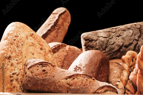 Fragrant bread on the table. Food concept in a wooden box on black background